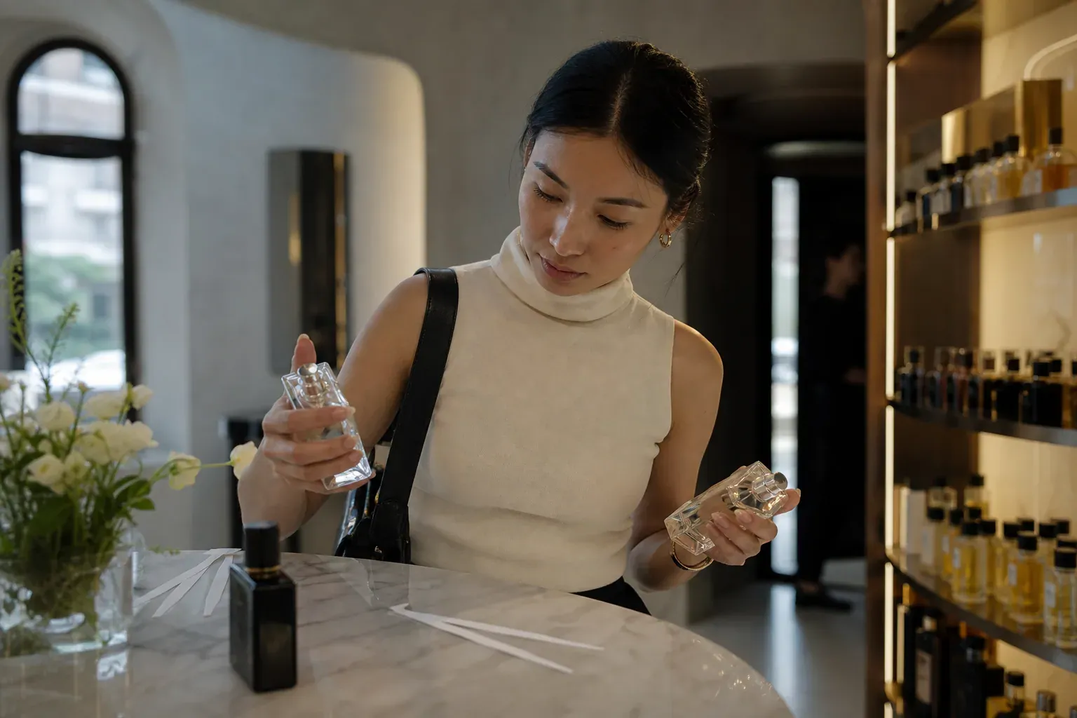 Photo réaliste d’une personne en boutique de parfum comparant deux flacons non marqués avec des touches à sentir, dans une lumière naturelle.
