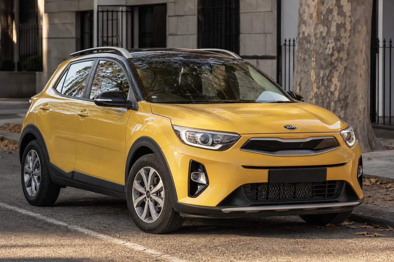 Un Kia Stonic gris vue de trois quarts avant, garé dans une rue urbaine moderne en plein jour.